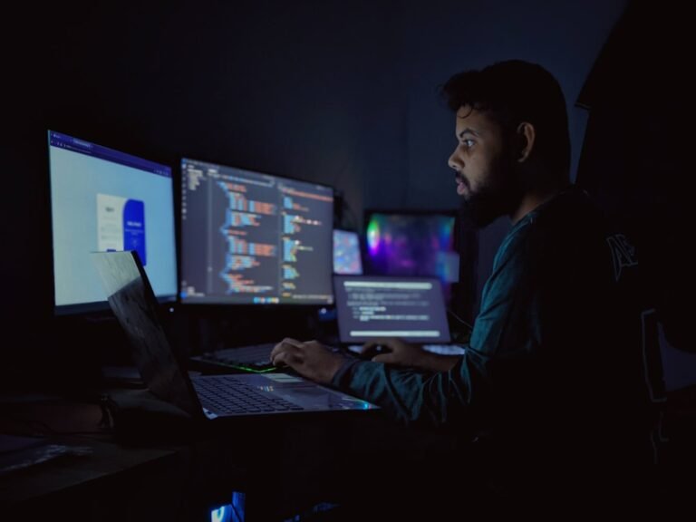 Um Homem Sentado Em Frente a Tres Monitores De Computador fdGTi4IcaJc