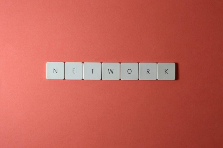 White keyboard tiles spelling 'NETWORK' on a vibrant red surface, minimalist design.