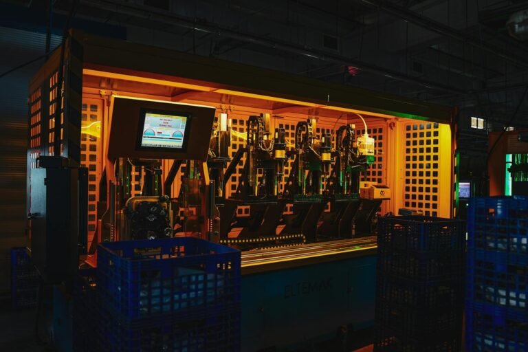 A complex piece of machinery in a dark industrial setting with vibrant lighting.