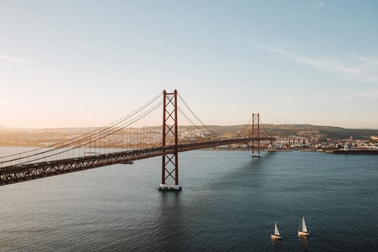 A stunning aerial view of the 25 de Abril Bridge spanning the Tagus River in Lisbon.